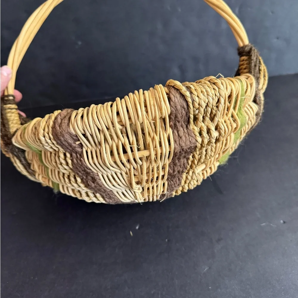 Vintage handwoven basket with brown and green yarn details and eye of God.
